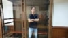 Reporter Wall Street Journal Evan Gershkovich berdiri di dalam sangkar kaca di ruang sidang Pengadilan Kota Moskow di Moskow, Rusia, Kamis, 22 Juni 2023. (AP/Dmitry Serebryakov)