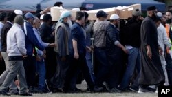 Mourners carry the body of a victim of the March 15 mosque shootings for burial at the Memorial Park Cemetery in Christchurch, New Zealand, March 20, 2019.