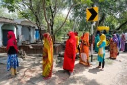 Indian village women line up outside a bank to withdraw 500 rupees received as relief money from government, during coronavirus lockdown in Fatehpur district, Uttar Pradesh state, India, May 11, 2020.