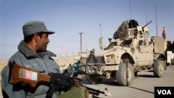 Seorang polisi Afghanistan siaga di dekat kendaraan militer AS di provinsi Kandahar (foto: dok.)