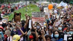 Para demonstran mengepalkan tangan mereka saat berunjuk rasa di Universitas Filipina dalam Perayaan Hari Kemerdekaan Filipina di Manila, Jumat, 12 Juni 2020.