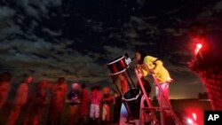 A student looks up at the moon through a telescope, during a visit by The Traveling Telescope to show students the science of astronomy, at St Andrew's School near Molo in Kenya's Rift Valley, Feb. 3, 2017.