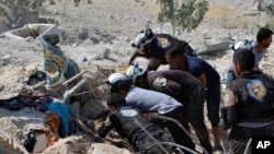 This photo provided by the Syrian Civil Defense White Helmets, which has been authenticated based on its contents and other AP reporting, shows Civil Defense workers searching through the rubble after airstrikes hit in Khan Sheikhoun, in the northern prov
