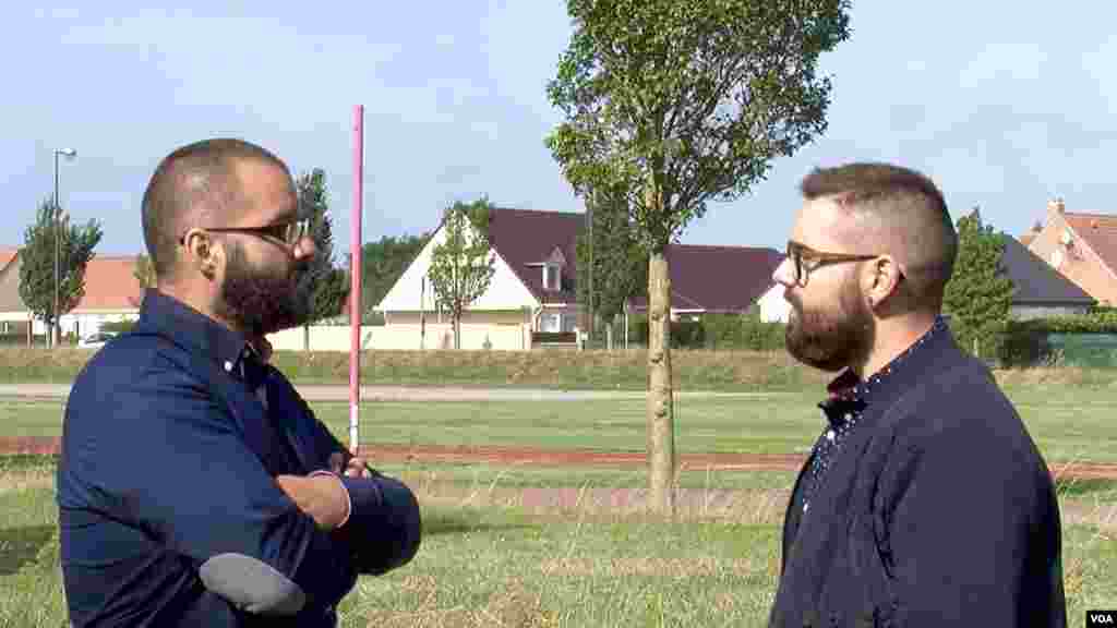 Rudy Vercucque (L), National Front regional councilor for the Hauts-de-France region that includes Calais is seen talking to another National Front member. (L. Bryant/VOA)
