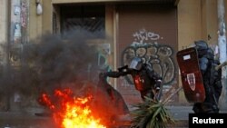 Riot police patrol remove a burning barricade set by demonstrators during protests after Ecuador's President Lenin Moreno's government ended four-decade-old fuel subsidies, in Quito, Ecuador, Oct. 4, 2019.