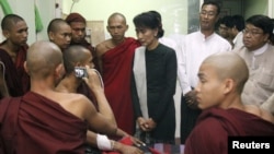 Burmese pro-democracy leader Aung San Suu Kyi visits Buddhist monks, wounded in a recent police crackdown on protesters against a copper mine project, November 29, 2012.