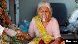 អ្នកស្រី Lilaben Gautambhai Modi អាយុ​៨០ឆ្នាំ អង្គុយ​នៅក្នុង​រថយន្ត​សង្គ្រោះ​បន្ទាន់ ខណៈពេល​ដែល​អ្នកស្រី​រង់ចាំ​ចូល​មន្ទីរពេទ្យ​​ដែល​ព្យាបាល​ជំងឺ​កូវីដ១៩ នៅ​ប្រទេសឥណ្ឌា កាលពី​ថ្ងៃទី៥ ខែឧសភា ឆ្នាំ២០២១។