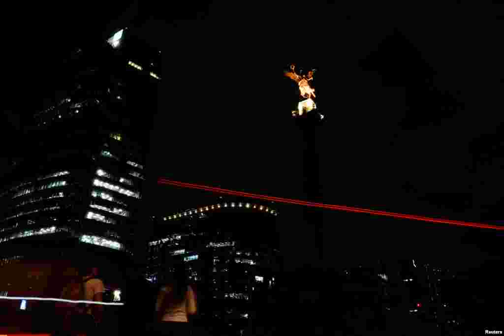 The Angel de la Independencia monument is pictured as lights are turned off during Earth Hour In Mexico City, March 30, 2019.