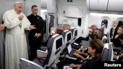 Pope Francis talks to journalists during a press conference aboard a plane to Rome at the end of his visit to Colombia, Sept. 11, 2017.