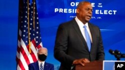 President-elect Joe Biden, left, listens as retired Army Gen. Lloyd Austin, Biden's choice to be secretary of defense, speaks during an event at The Queen theater in Wilmington, Del., Dec. 9, 2020. 