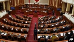 FILE - Albania's Prime Minister Edi Rama delivers a speech to the parliament with the seats of the main opposition Democratic party, left, empty, during an assembly session in Tirana, Feb. 23, 2017.