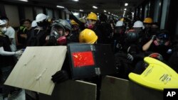 Para demonstran menggunakan berbagai benda untuk melindungi diri berusaha melewati stasiun kereta bawah tanah menuju ke kantor polisi di Hong Kong, 4 Agustus 2019. (Foto: AP)