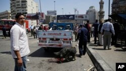 Security personnel use a bomb-sniffing dog at the scene of an explosion that killed at least one person on a bridge over the Nile River, near an upscale neighborhood of Cairo, Egypt, April 5, 2015. 