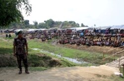 FILE - A Bangladeshi soldier stands guard near a refugee camp in Cox's Bazar, Bangladesh, housing Rohingya refugees from Myanmar's Rakhine state, April 29, 2018.