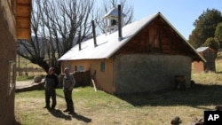'Hermanos' Fidel Trujillo, left, and Leo Paul Pacheco, look at the kitchen recently built with adobe next to the 1860s 'morada' de San Isidro, which is the main chapel and meeting point of their Catholic brotherhood, outside Holman, New Mexico, April 15, 2023.