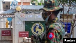 Un soldat se tient devant la Banque centrale du Myanmar lors d'une manifestation contre le coup d'État militaire, à Yangon, au Myanmar, le 15 février 2021.