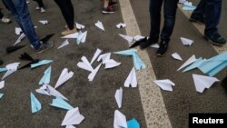 People stand next to paper planes, symbol of Telegram messenger, released during a rally in protest against court decision to block the messenger because it violated Russian regulations, in Moscow, April 30, 2018. 