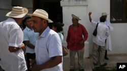 In this Dec. 17, 2017 photo, men wearing traditional Panamanian pintao hats leave Sunday Mass in La Pintada, Panama. (AP Photo/Arnulfo Franco)