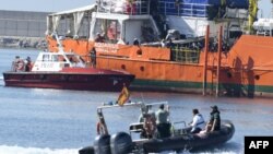 Des migrants se tiennent sur le pont de l'Aquarius alors que le navire entre dans le port de Valence, le 17 juin 2018.