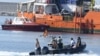 Des migrants se tiennent sur le pont de l'Aquarius alors que le navire entre dans le port de Valence, le 17 juin 2018.