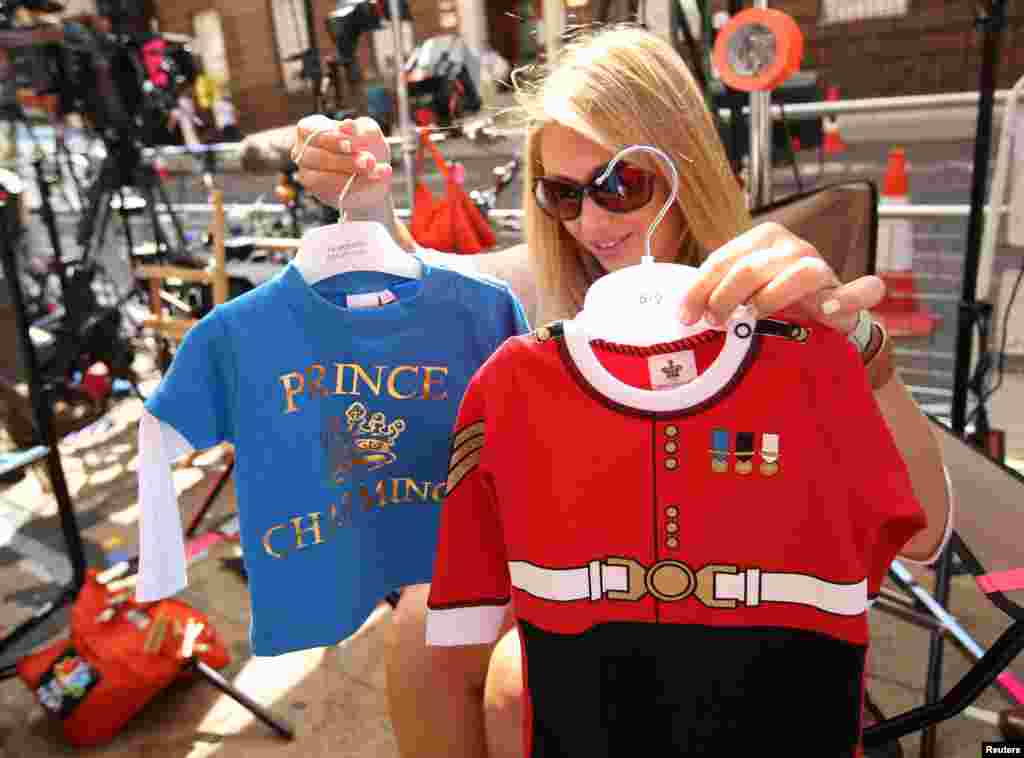 Reporter dari media Amerika memilih baju bayi mana yang akan diperlihatkan di kamera (15/7) di luar Sayap Lindo, Rumah Sakit St. Mary&#39;s, tempat Duchess of Cambridge akan melahirkan di London. (Reuters/Olivia Harris)