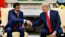 President Donald Trump shakes hands with Qatar's Emir Sheikh Tamim Bin Hamad Al-Thani in the Oval Office of the White House, Tuesday, July 9, 2019, in Washington. (AP Photo/Evan Vucci)
