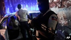 A police officer stands at an intersection in Port-au-Prince, Haiti, late Wednesday, July 14, 2021. Haiti is in the midst of a heightened security situation after the July 7 assassination of President Jovenel Moise. (AP Photo/Matias Delacroix)