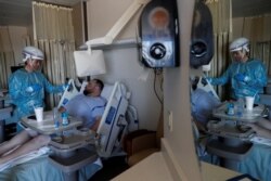 FILE - Dr. Manuel Gordillo speaks with Matthew Soriano, a coronavirus disease (COVID-19) positive patient, during medical rounds in the COVID unit at Sarasota Memorial Hospital in Sarasota, Florida, Feb. 11, 2021.