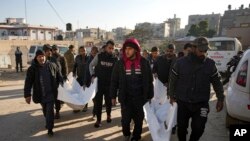 Familjarët bartin trupat e të vrarëve nga bombardimet izraelite në Rrioin e Gazës për t'i varrosur në Deir al-Balah, më 8 janar, 2025/AP