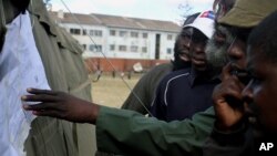 Voters look at posted results for Zimbabwe's national elections outside of a polling station in Harare August 1, 2013. 