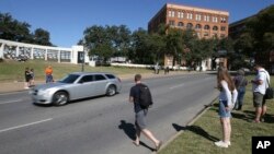 Tourists gather on the street where President John F. Kennedy's was shot from 6th floor of the book depository at Dealey Plaza in downtown Dallas, Oct. 25, 2017. 