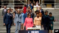 In this July 25, 2019, photo, House Speaker Nancy Pelosi of Calif., and House Democrats arrive for a news conference on the first 200 days of the 116th Congress at the House East Front steps of the Capitol in Washington. Nearly half the House…