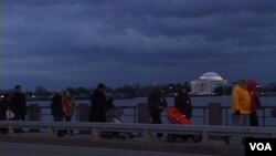 Para peserta 'Stand with Japan' menyeberangi jembatan dekat Tidal Basin.