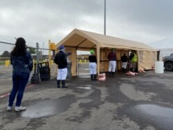 Workers line up to be tested for COVID-19 at the Seaboard Foods hog-processing plant in Guymon, Oklahoma, U.S., May 13, 2020.