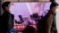 Men walk past a TV broadcasting a news report on North Korea firing a ballistic missile off its east coast, in Seoul, South Korea, Nov. 3, 2022. 