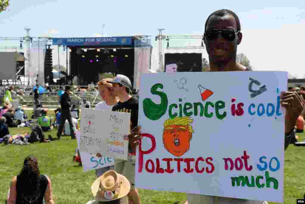 អ្នក​ចូលរួម​ម្នាក់​កាន់​បដា​របស់​គាត់​នៅ​ឯ​ចលនា​ដើរ​ជា​ក្បួន​ដើម្បី​លើក​កម្ពស់​វិទ្យាសាស្ត្រ។ (ចាប ចិត្រា/VOA)