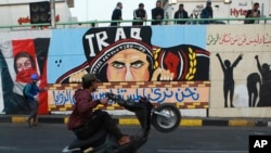 In this Sunday, Nov. 17, 2019 photo, a protestor races his motorbike past graffiti in the Saadoun Tunnel, in Baghdad, Iraq. The underpass running beneath Baghdad’s Tahrir Square has become an ad hoc museum chronicling Iraq’s massive anti-government protes