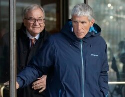 FILE - William "Rick" Singer, front, founder of the Edge College & Career Network, exits federal court in Boston, March 12, 2019, after he pleaded guilty to charges in a nationwide college admissions bribery scandal.