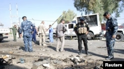 Pasukan keamanan Irak memeriksa lokasi serangan bom bunuh diri di Kut, 150 kilometer sebelah tenggara Baghdad (30/9). Serangan ini menewaskan sedikitnya 4 polisi setempat. 