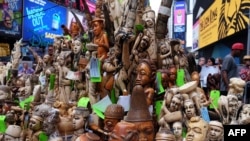 People look at a pile of artworks made out of ivory during a ceremony at the Times Square in New York, June 19, 2015. 