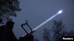 Vladyslav Tsukurov, judge and spokesperson of Bila Tserkva district court, observes the sky during a combat shift of his air defence volunteer unit, amid Russia's attack on Ukraine, in Kyiv region, Ukraine November 30, 2024.