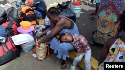  FILE - Migrants from Cameroon rest while waiting with other migrants from Africa and Haiti to request humanitarian visas, issued by the Mexican government, to cross the country towards the United States, in Tapachula, Mexico June 27, 2019. 