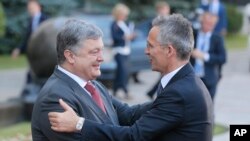 Ukrainian President, Petro Poroshenko, left, and NATO Secretary General Jens Stoltenberg, shake hands during a meeting in Kiev, Ukraine, July 10, 2017. 