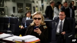 FILE - Then-Secretary of State Hillary Rodham Clinton checks her Blackberry from a desk inside a C-17 military plane upon her departure from Malta, in the Mediterranean Sea, bound for Tripoli, Libya, Oct. 18, 2011. Clinton used a personal email account during her time as secretary of state, rather than a government-issued email address, potentially hampering efforts to archive official government documents required by law.