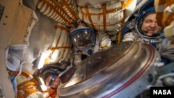 NASA astronaut Jeff Williams, left, Russian cosmonaut Alexey Ovchinin of Roscosmos, center, and Russian cosmonaut Oleg Skripochka of Roscosmos are seen inside the Soyuz TMA-20M spacecraft a few moments after they landed in a remote area in Kazakhstan.