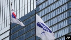FILE - A flag of Samsung, right, and South Korean national flag are seen outside the Samsung Electronics' Seocho building in Seoul, South Korea, July 5, 2024.