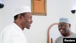 Nigeria's President Muhhamadu Buhari (L) is joined by former Vice President Alhaji Atiku Abubakar as they attend the Jumaat Prayers after Alhaji Atiku Abubakar returned from medical treatment overseas, in Abuja, Nigeria. Buhari's cabinet is finally being 