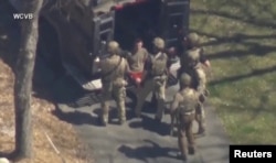 미 연방수사국(FBI) 요원들이 지난 13일 매사추세츠 주방위군 공군 잭 테세이라(가운데 붉은 하의) 일병을 체포하고 있다. (자료사진)