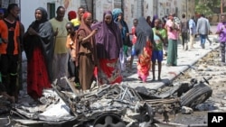 Warga Somalia berkerumun di dekat rongsokan bom mobil pasca ledakan di Mogadishu, Selasa (21/4).