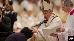 Pope Francis baptizes Rachel Khayesi of Kenya during an Easter vigil service in St. Peter's Basilica at the Vatican, April 4, 2015.
